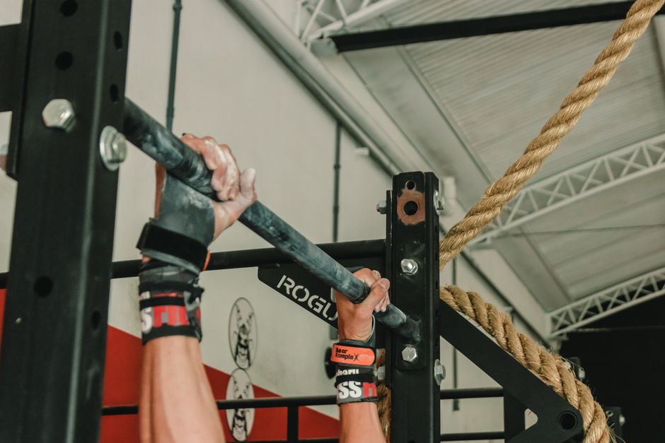 Gants de musculation portés pendant une traction à la barre de porte