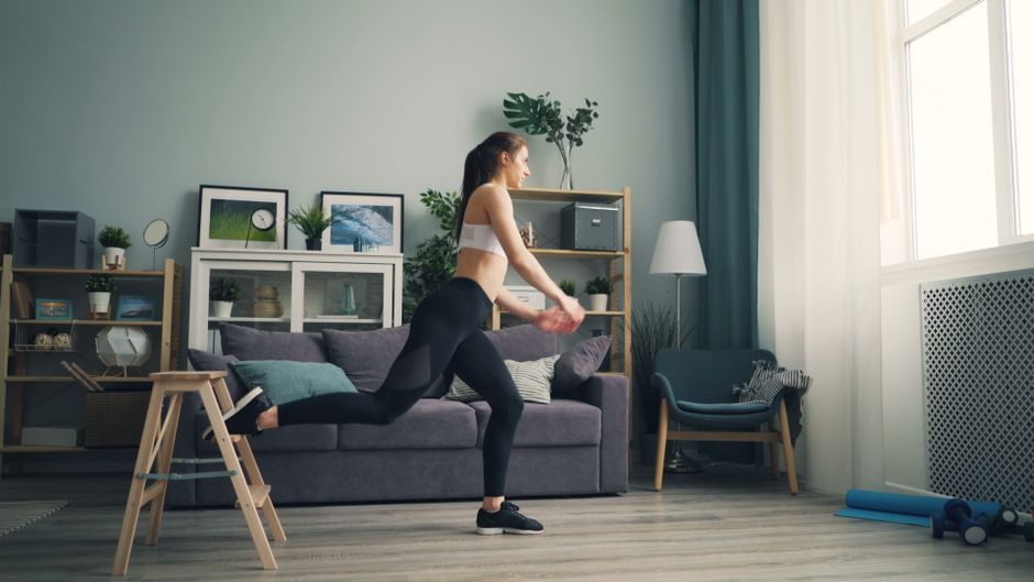 Femme réalisant un squat au poids du corps dans un salon