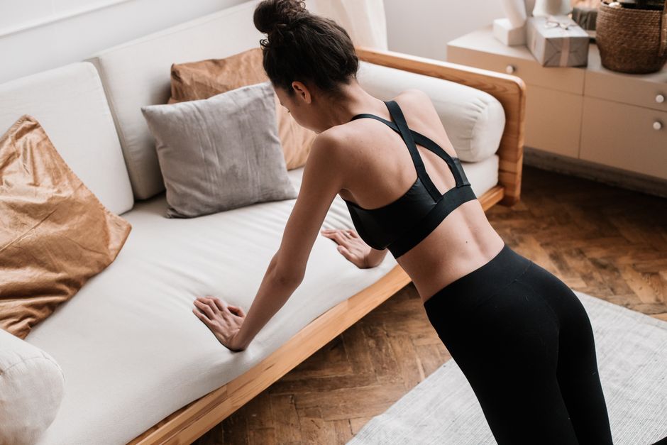 Femme réalisant une pompe classique au sol dans un salon