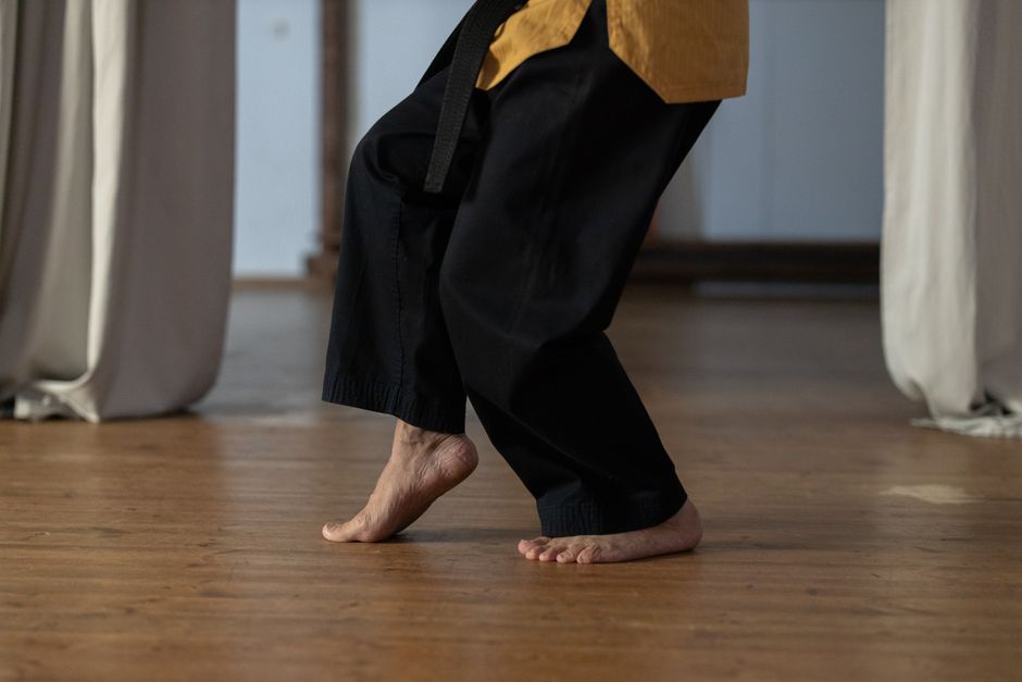 Marche sur pointes de pieds sur parquet, talons décollés, dans un salon d'appartement