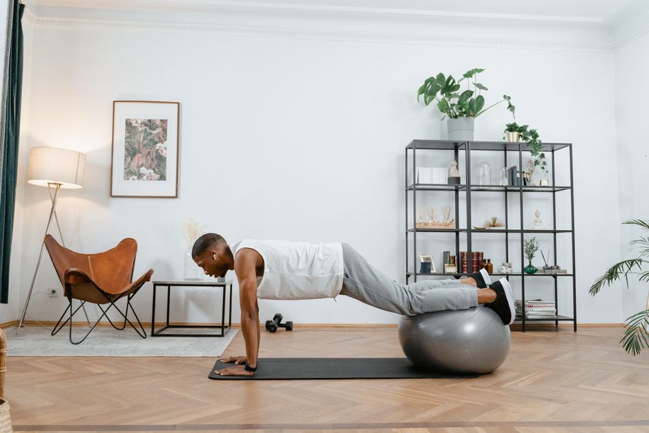 Pratiquant en position de planche haute sur le sol d'un salon, dos aligné
