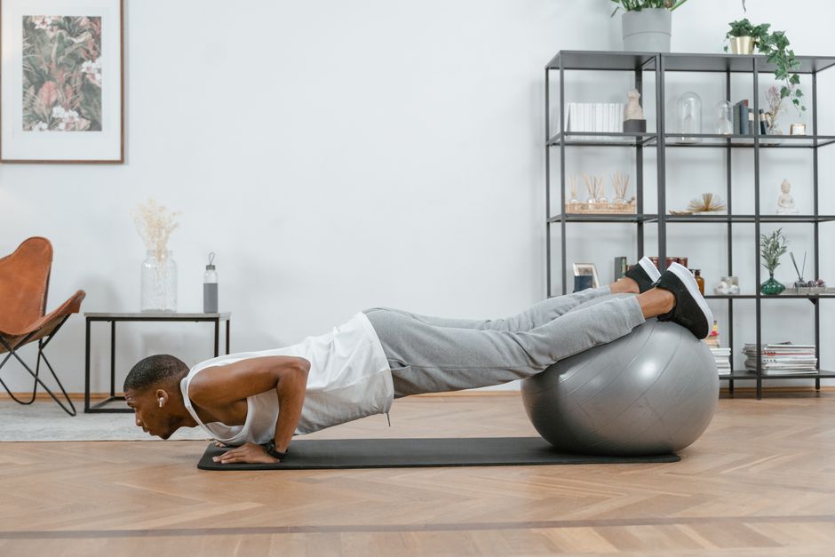 Homme réalisant une pompe inclinée mains sur une chaise dans un salon