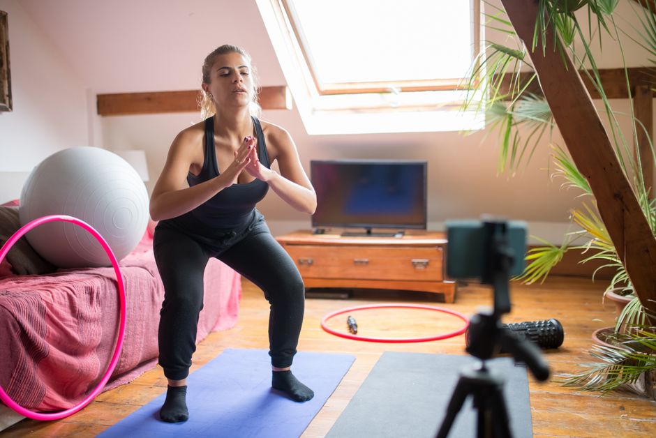 Femme en position basse d'air squat, hanches sous la parallèle, dans un salon