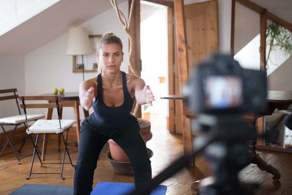 Squat au poids du corps réalisé dans un salon, exercice central du full body maison